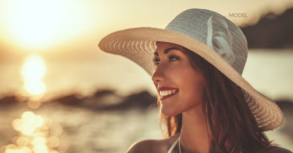 woman (model) with smooth skin admiring the sunset at a local beach.