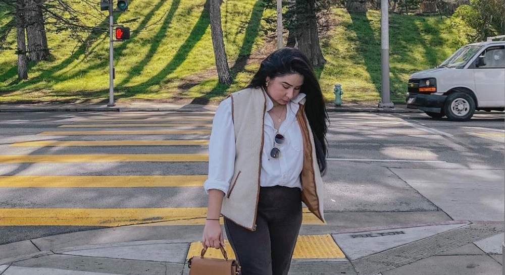 Pamela looking confident while walking on a sidewalk, looking downward