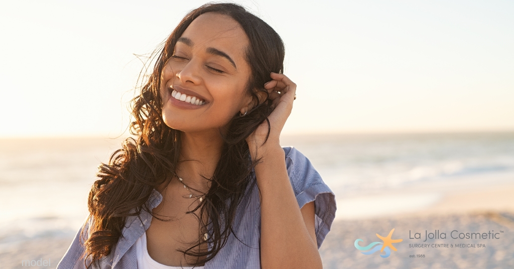 image of woman smiling on the beach (model)